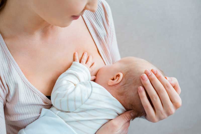 woman breastfeeding newborn